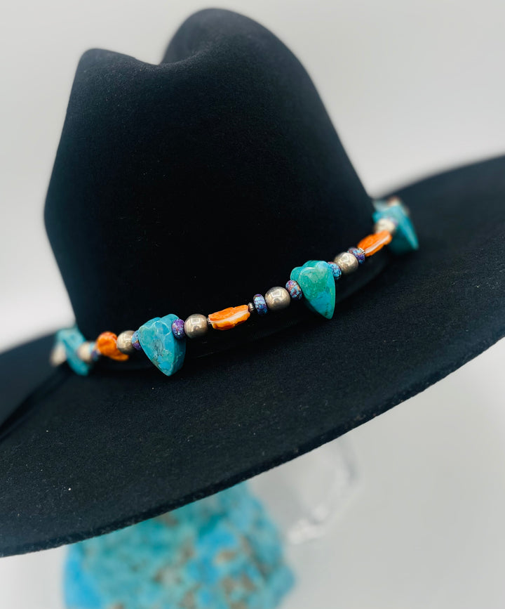 Adjustable beaded hatband featuring Kingman turquoise, purple Mojave turquoise, spiney oyster and turquoise hearts, sterling silver beads, and finished with deer lace in the back. Available only from Rockstar Cowgirl online or in store in Cody, Wyoming.