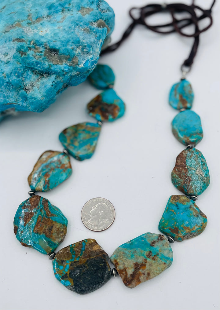 Adjustable beaded hatband that double as a necklace featuring Kingman turquoise flats and sterling silver beads finished with deer lace in the back. U.S. quarter for size reference. Available only from Rockstar Cowgirl online or in store in Cody, Wyoming.