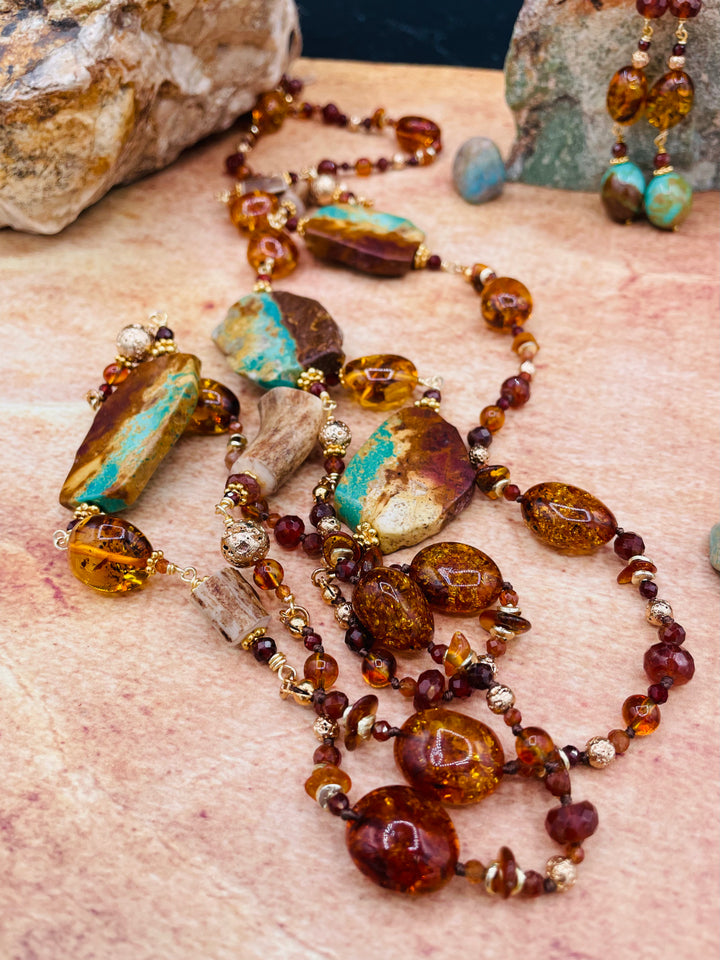 A close up of the Baltic amber, garnets, Kingman turquoise, and deer antler beads in this silk knotted and wire wrapped treasure necklace set with matching earrings. Available only from Rockstar Cowgirl online and in store in Cody, Wyoming.