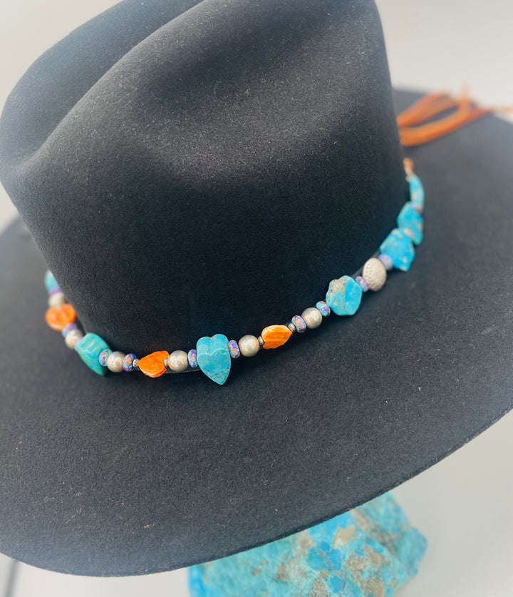 Adjustable beaded hatband featuring Kingman turquoise, purple Mojave turquoise, spiney oyster and turquoise hearts, sterling silver beads, and finished with deer lace in the back. Available only from Rockstar Cowgirl online or in store in Cody, Wyoming.