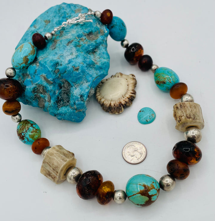 Chunky beaded necklace featuring Baltic amber, textured deer antler, sterling silver beads, and Kingman turquoise nuggets. U.S. quarter for size reference. Available only from Rockstar Cowgirl online or in store in Cody, Wyoming.