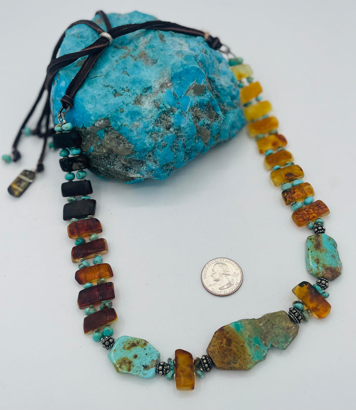 Adjustable beaded hatband featuring Kingman turquoise, Sonoran turquoise, Baltic amber with silver details, and finished with deer lace in the back. U.S. quarter for size reference. Available only from Rockstar Cowgirl online or in store in Cody, Wyoming.