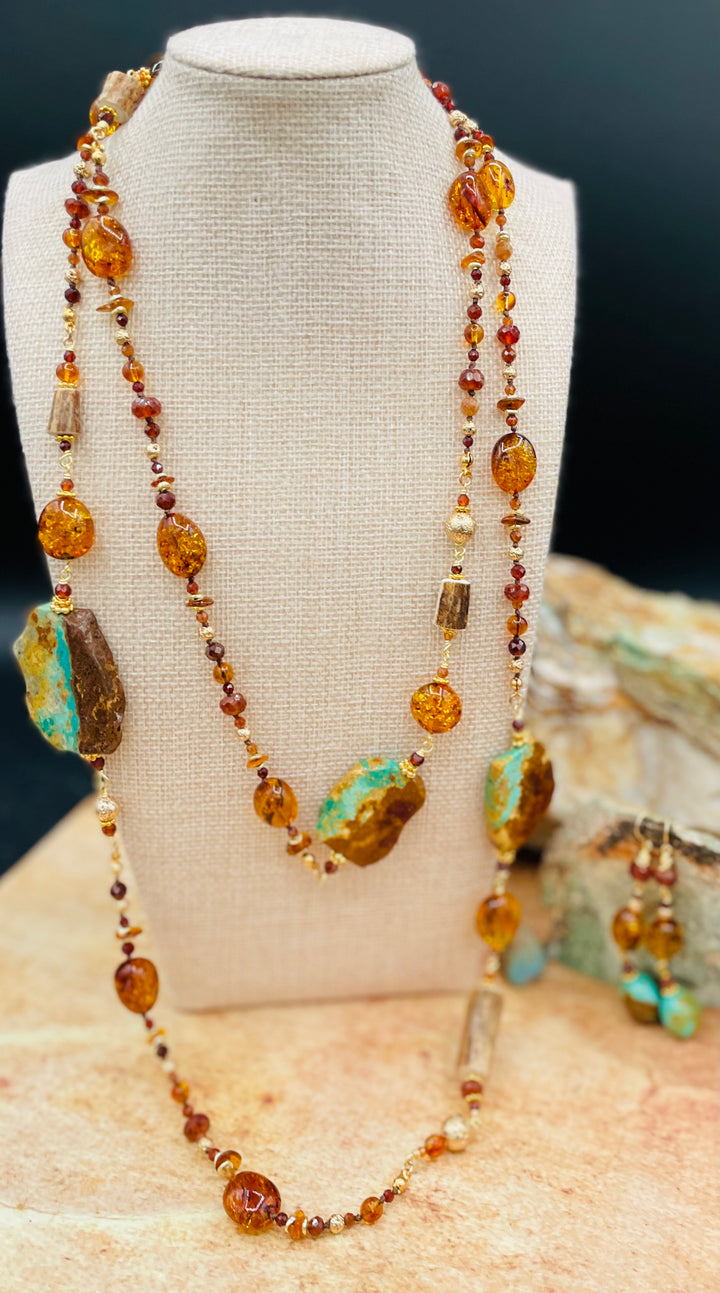 Extra long silk knotted and wire wrapped treasure necklace featuring Baltic amber, Kingman turquoise, garnets, and deer antler with matching earrings. Available only from Rockstar Cowgirl online or in store in Cody, Wyoming.