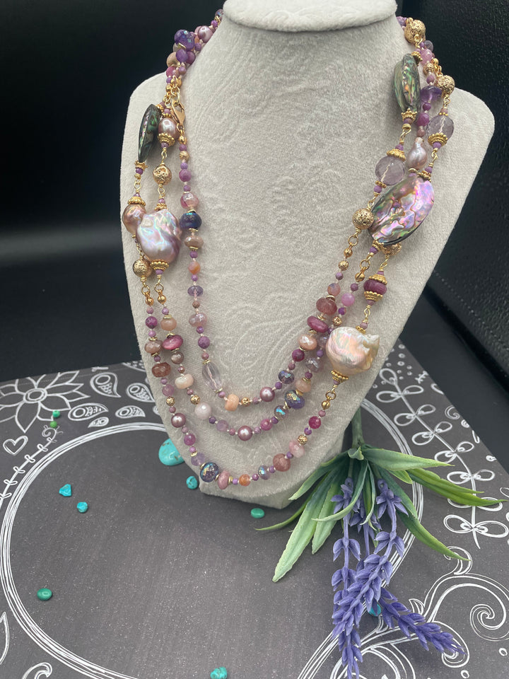Silk knotted and wire wrapped treasure necklace featuring giant baroque pearls, abalone shells, rubies, pink amethyst, pink tourmaline, and moonstones. Available only from Rockstar Cowgirl online or in store in Cody, Wyoming.