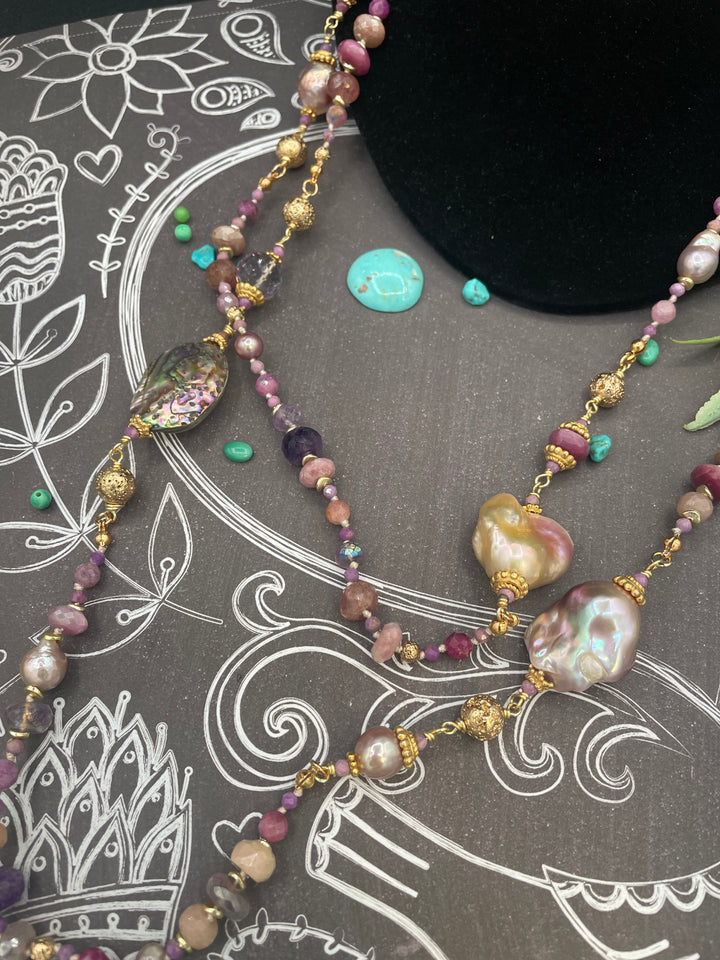 Close up of the baroque natural luster pearls, rubies, pink amethyst, pink tourmaline, moonstone, and abalone in this silk knotted and wire wrapped treasure necklace. Available only from Rockstar Cowgirl online or in store in Cody, Wyoming.