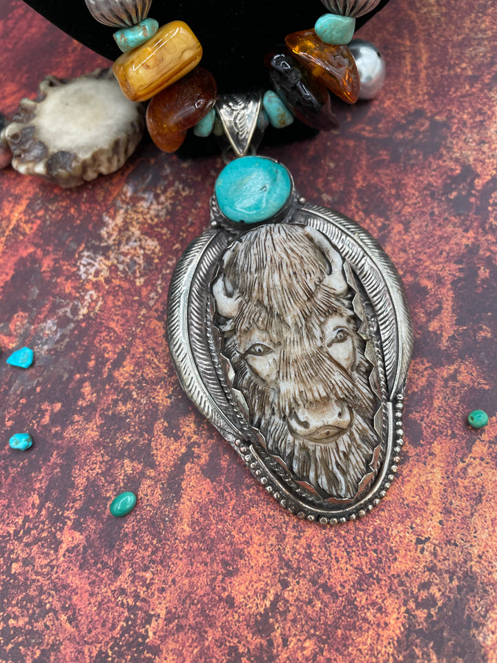 A detail photo of the bison pendent with turquoise accent.