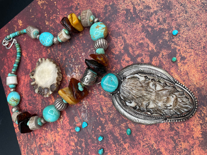 Close up of the Bison pendent. Hand carved in bone with a turquoise accent and set in silver. Available in Cody, Wy at Rockstar Cowgirl or online. One of a kind piece.