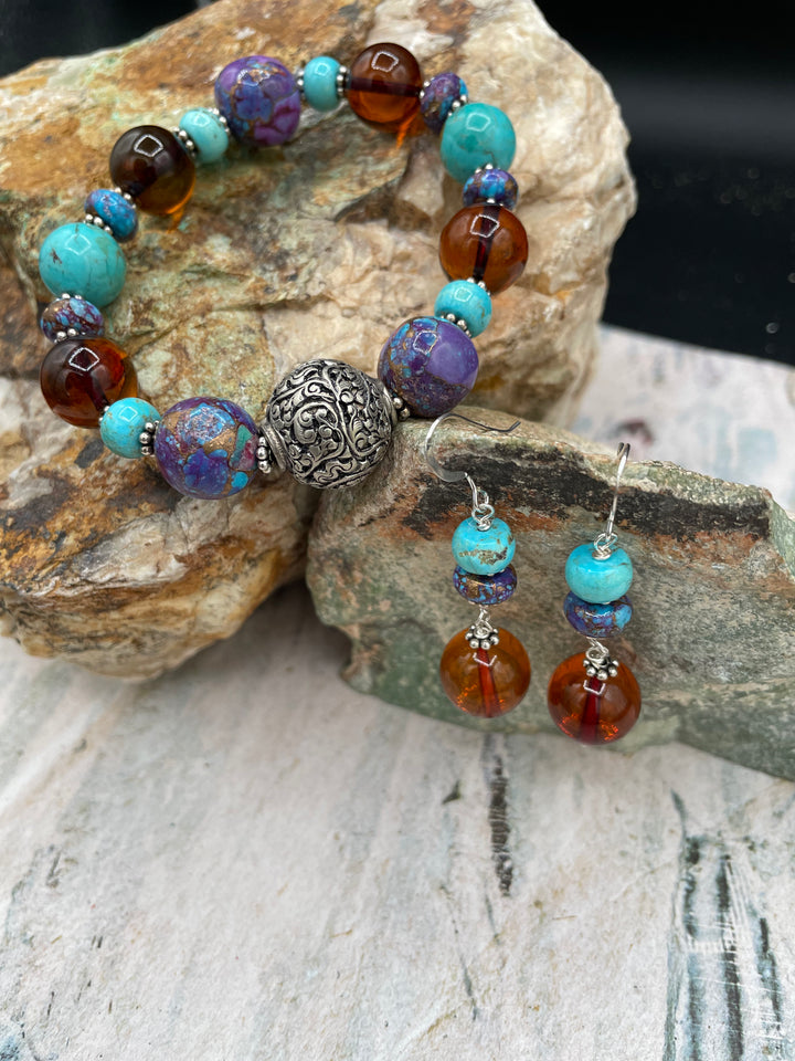 A bracelet and earrings set. This set features Baltic amber, purple Mojave and Kingman turquoise with sterling silver.