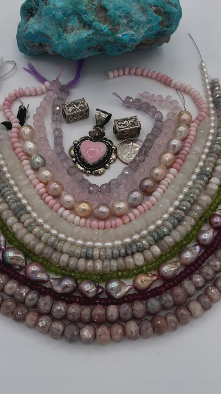 Bead box featuring strands of silverite, ruby, pearls, peridot, moonstone, opal, rose quartz, pink amethyst, with Repousse beads, and a pink conch shell pendant. U.S. quarter for size reference. Available only from Rockstar Cowgirl online or in store in Cody,Wyoming.