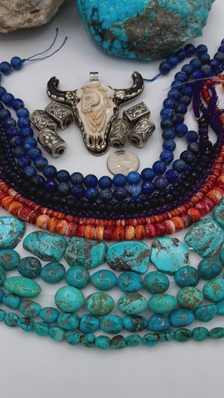 Bead box featuring strands of lapis, amethyst, spiney oyster, Kingman turquoise, Campitios turquoise, Repousse beads, with a bone and Bali silver steer pendent. U.S. quarter for size reference. Available only from Rockstar Cowgirl online or in store in Cody, Wyoming.