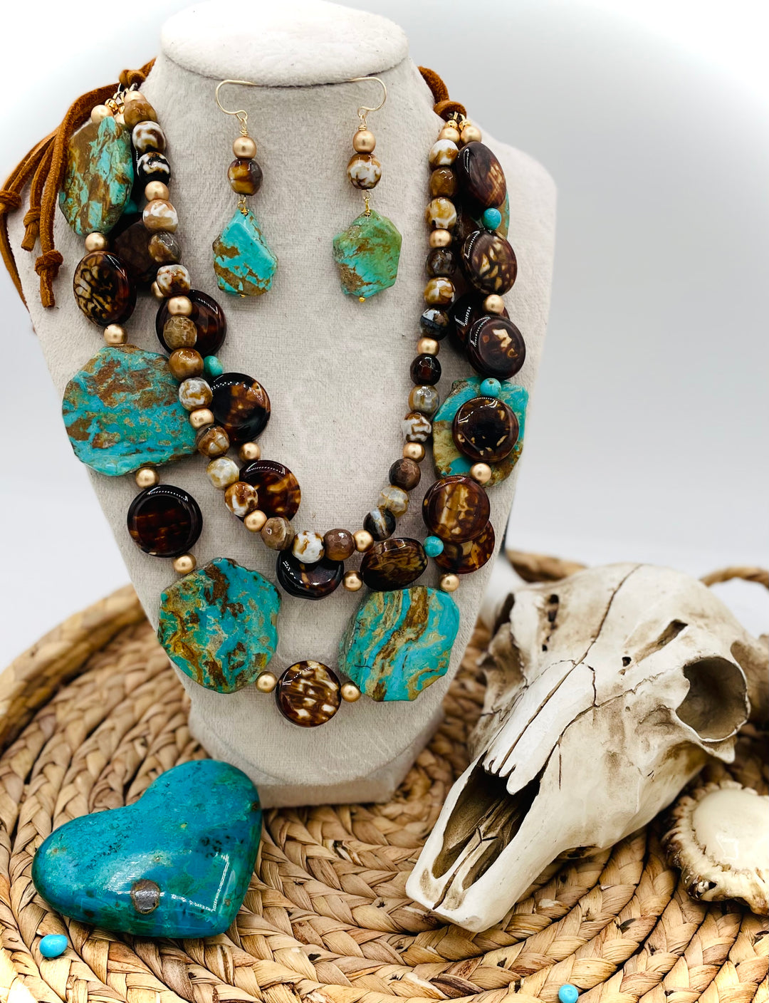 Beaded three strand necklace featuring Kingman turquoise, fire agate, gold hematite, deer lace, and slide bead. Includes matching earrings. Available only from Rockstar Cowgirl online or in store in Cody, Wyoming.
