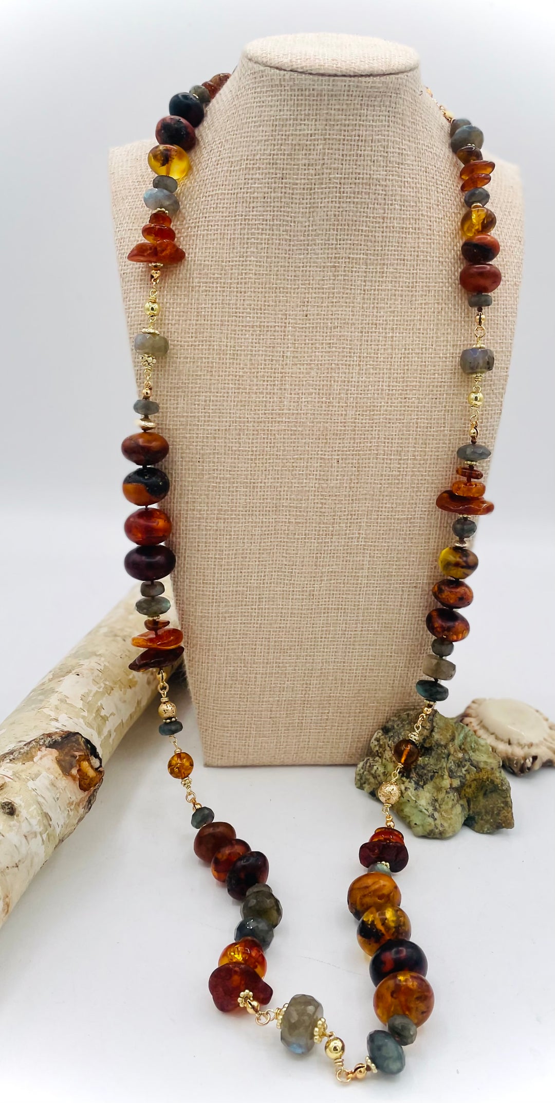 Silk knotted and wire wrapped treasure necklace featuring Baltic amber, labradorite, lava beads, and 14k gold accents. Available only from Rockstar Cowgirl online or in store in Cody, Wyoming. 