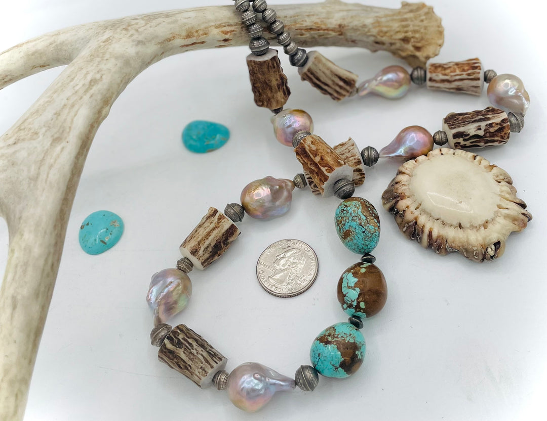 Handmade beaded necklace featuring textured deer antler beads, #8 turquoise nuggets, natural luster flameball pearls, and sterling silver beads. U.S. quarter for size reference.  Available only from Rockstar Cowgirl online or in store in Cody, Wyoming. 
