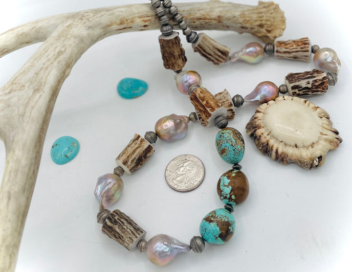 Handmade beaded necklace featuring textured deer antler beads, #8 turquoise nuggets, natural luster flameball pearls, and sterling silver beads. U.S. quarter for size reference.  Available only from Rockstar Cowgirl online or in store in Cody, Wyoming. 