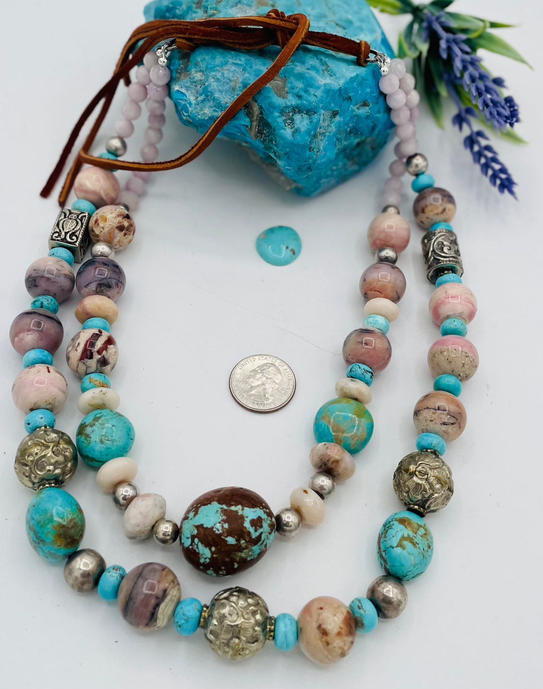 Adjustable beaded necklace featuring Pink opal, Royal beauty turquoise, Serling silver beads, Kingman turquoise, Repousse beads, pink morganite, number 8 turquoise nuggets, and finished with deer leather lace. U.S. quarter for size reference. Available only from Rockstar Cowgirl online or in store in Cody, Wyoming.