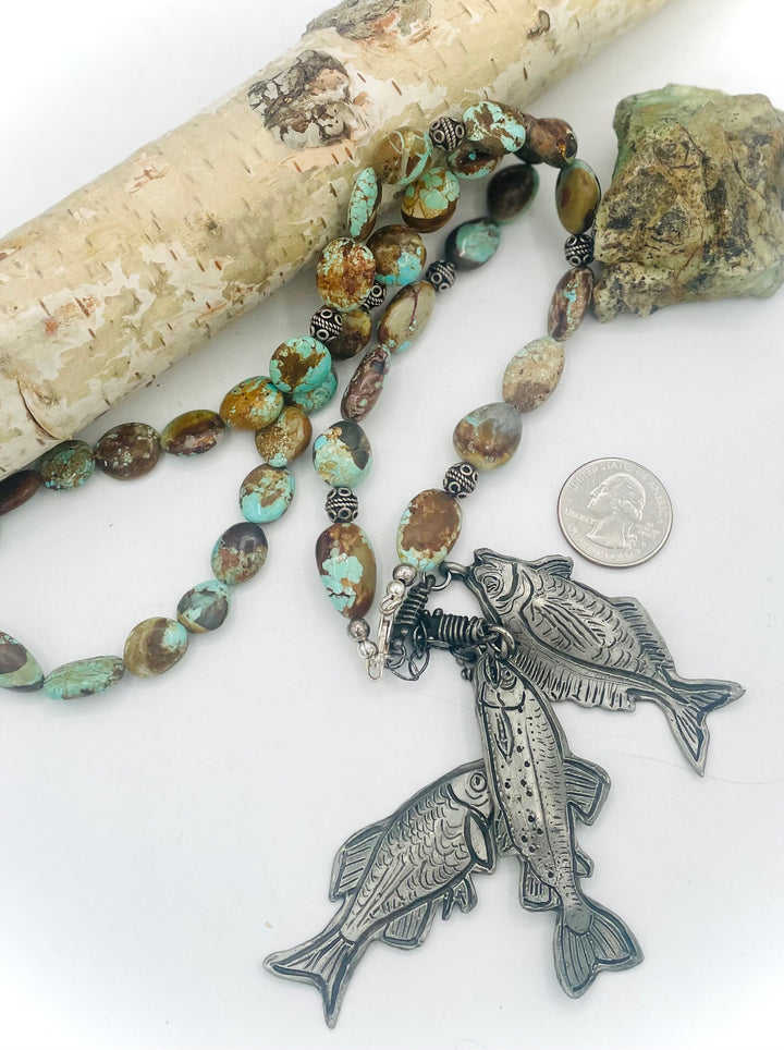 Beaded necklace featuring vintage #8 turquoise nuggets, sterling silver beads, and handmade sterling silver signed fish charms. Marcie. U.S. quarter for size reference. Available only from Rockstar Cowgirl online or in store in Cody, Wyoming.