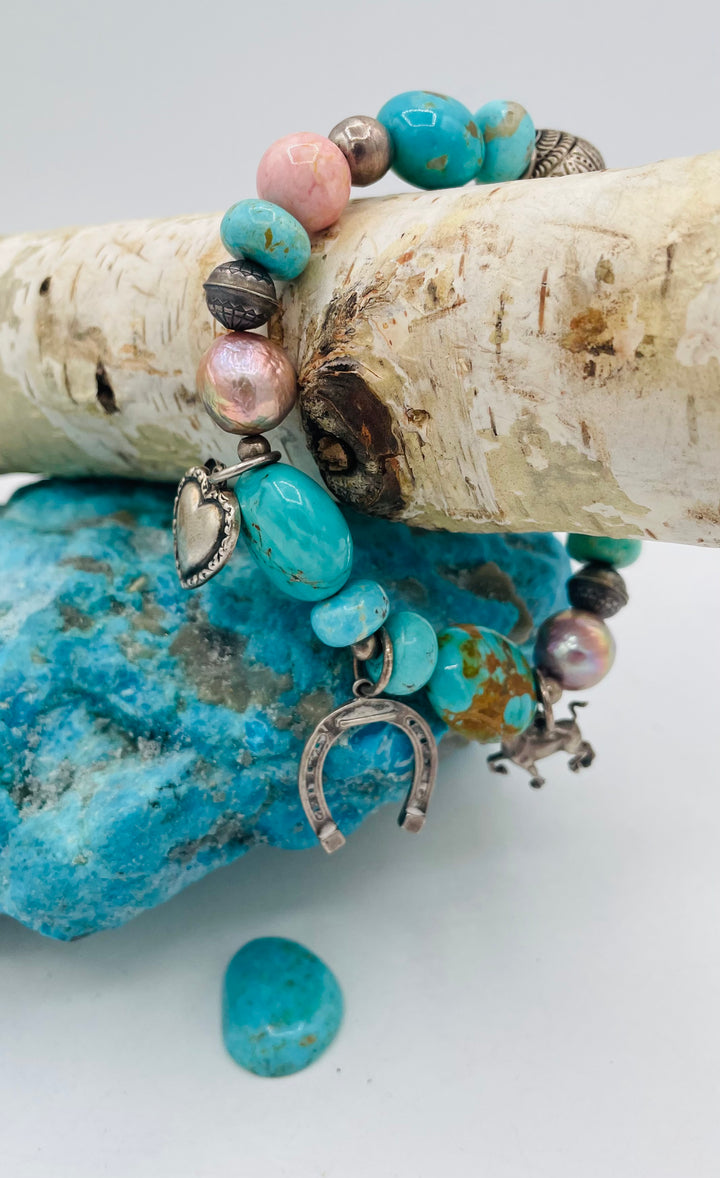 Beaded stretch bracelet featuring Kingman turquoise, royal beauty turquoise, pearls, rhodochrosite, purple turquoise, sterling silver beads and vintage sterling silver charms. Available only from Rockstar Cowgirl online or in store in Cody, Wyoming.