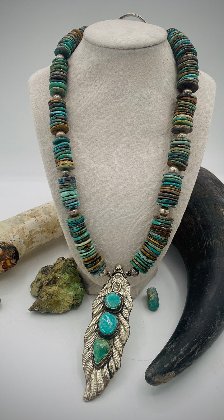 Handmade beaded necklace featuring turquoise discs, sterling silver beads, and Tibetan silver pendent with turquoise inlays. Available only from Rockstar Cowgirl online or in store in Cody, Wyoming.