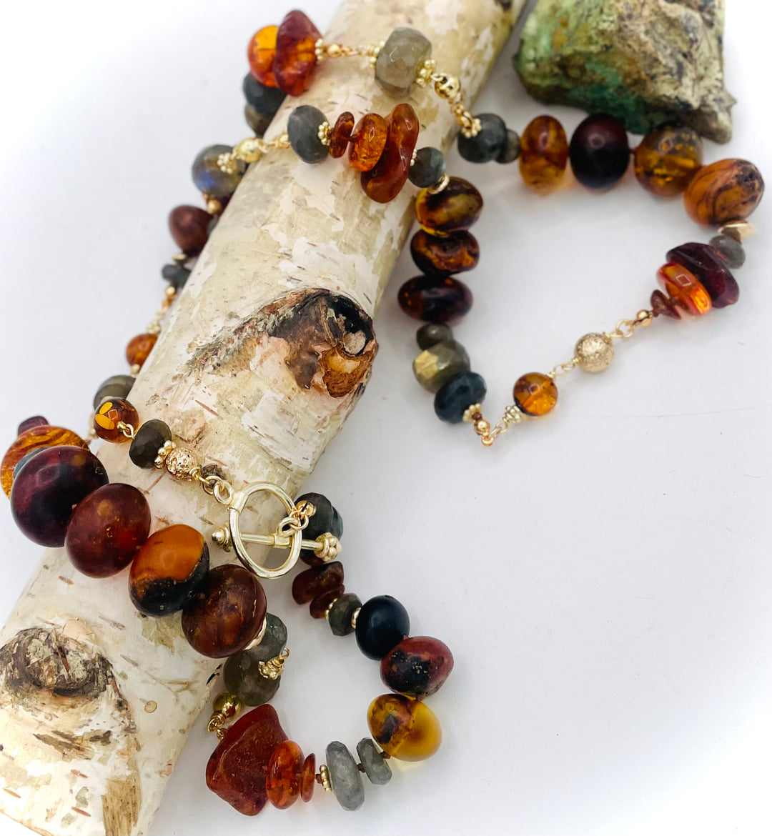 Silk knotted and wire wrapped treasure necklace featuring Baltic amber, labradorite, lava beads, and 14k gold accents. Available only from Rockstar Cowgirl online or in store in Cody, Wyoming. 