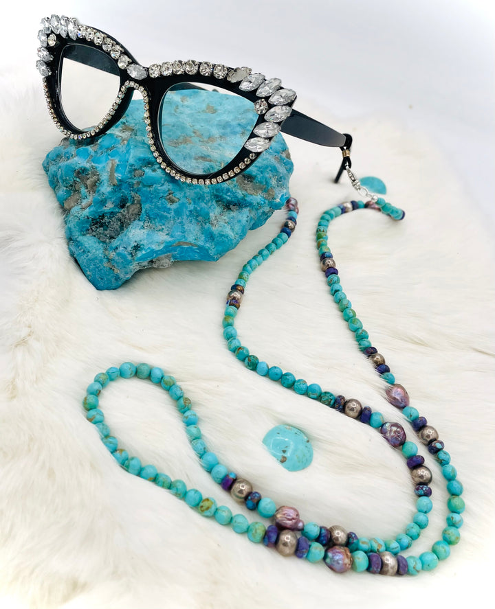 Beaded invention necklace featuring Kingman turquoise, Mojave Mohave turquoise, peacock pearls, sterling silver beads, and sterling silver swivel lobsters, with eye glasses loops and cell phone case attachment brackets. Available only from Rockstar Cowgirl online or in store in Cody, Wyoming.