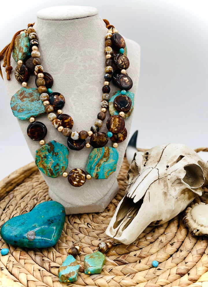 Beaded three strand necklace featuring Kingman turquoise, fire agate, gold hematite, deer lace, and slide bead. Includes matching earrings. Available only from Rockstar Cowgirl online or in store in Cody, Wyoming.