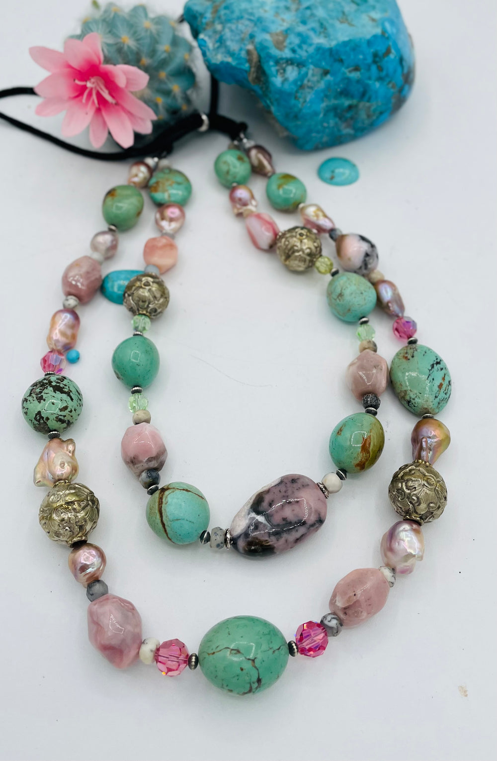 Adjustable beaded necklace featuring Kingman turquoise nuggets, pink opal, pearls, Swarovski crystals, dendrite opal, sterling silver beads, repousse beads, and finished with deer lace and slide bead. Available only from Rockstar Cowgirl online or in store in Cody, Wyoming.