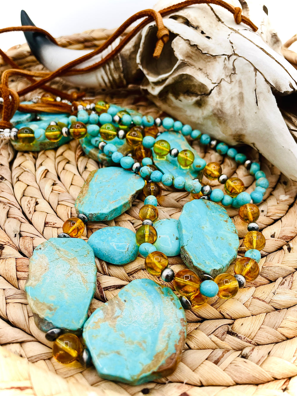 Beaded three strand necklace featuring Kingman turquoise, Baltic amber, sterling silver beads, and finished with deer lace and slide bead. Includes matching earrings. Available only from Rockstar Cowgirl online or in store in Cody, Wyoming.
