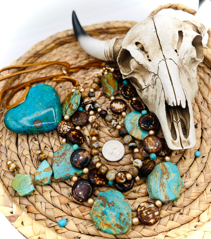 Beaded three strand necklace featuring Kingman turquoise, fire agate, gold hematite, deer lace, and slide bead. Includes matching earrings. U.S. quarter for size reference. Available only from Rockstar Cowgirl online or in store in Cody, Wyoming.