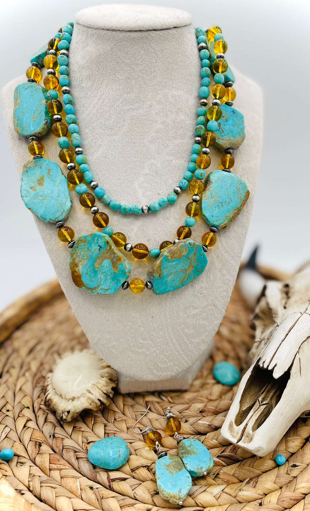 Beaded three strand necklace featuring Kingman turquoise, Baltic amber, sterling silver beads, and finished with deer lace and slide bead. Includes matching earrings. Available only from Rockstar Cowgirl online or in store in Cody, Wyoming.