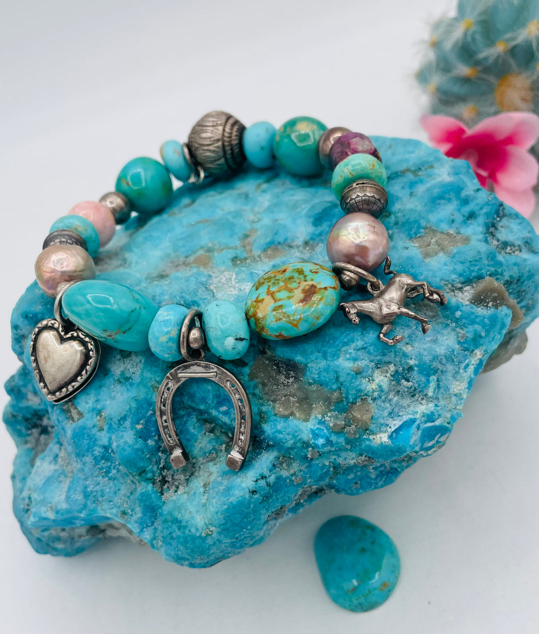 Beaded stretch bracelet featuring Kingman turquoise, royal beauty turquoise, pearls, rhodochrosite, purple turquoise, sterling silver beads and vintage sterling silver charms. Available only from Rockstar Cowgirl online or in store in Cody, Wyoming.