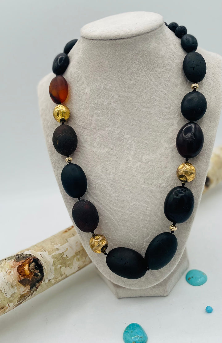 Silk knotted necklace featuring black Baltic amber nuggets, lava, and 14K gold beads. Available only from Rockstar Cowgirl online or in store in Cody, Wyoming.