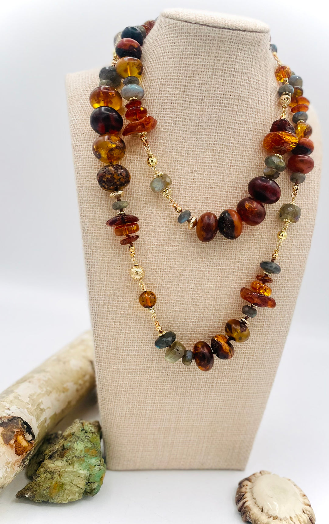 Silk knotted and wire wrapped treasure necklace featuring Baltic amber, labradorite, lava beads, and 14k gold accents. Available only from Rockstar Cowgirl online or in store in Cody, Wyoming. 