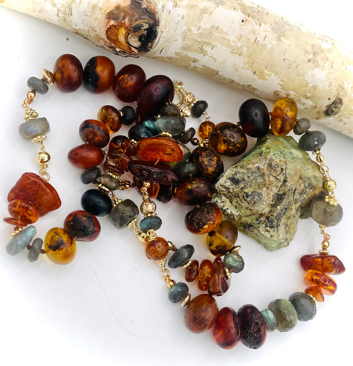 Silk knotted and wire wrapped treasure necklace featuring Baltic amber, labradorite, lava beads, and 14k gold accents. Available only from Rockstar Cowgirl online or in store in Cody, Wyoming. 