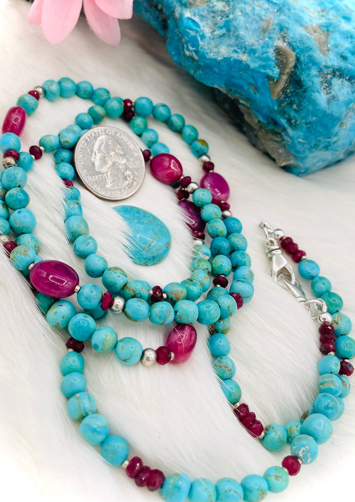 Beaded necklace, phone holder strap, or eye glass holder featuring blue Kingman turquoise, pink ruby nuggets and rondelles, sterling silver and African silver beads, sterling silver swivel lobsters, phone case attachments,  and glasses loops. U.S. quarter for size reference. Available only from Rockstar Cowgirl online or in store in Cody, Wyoming.
