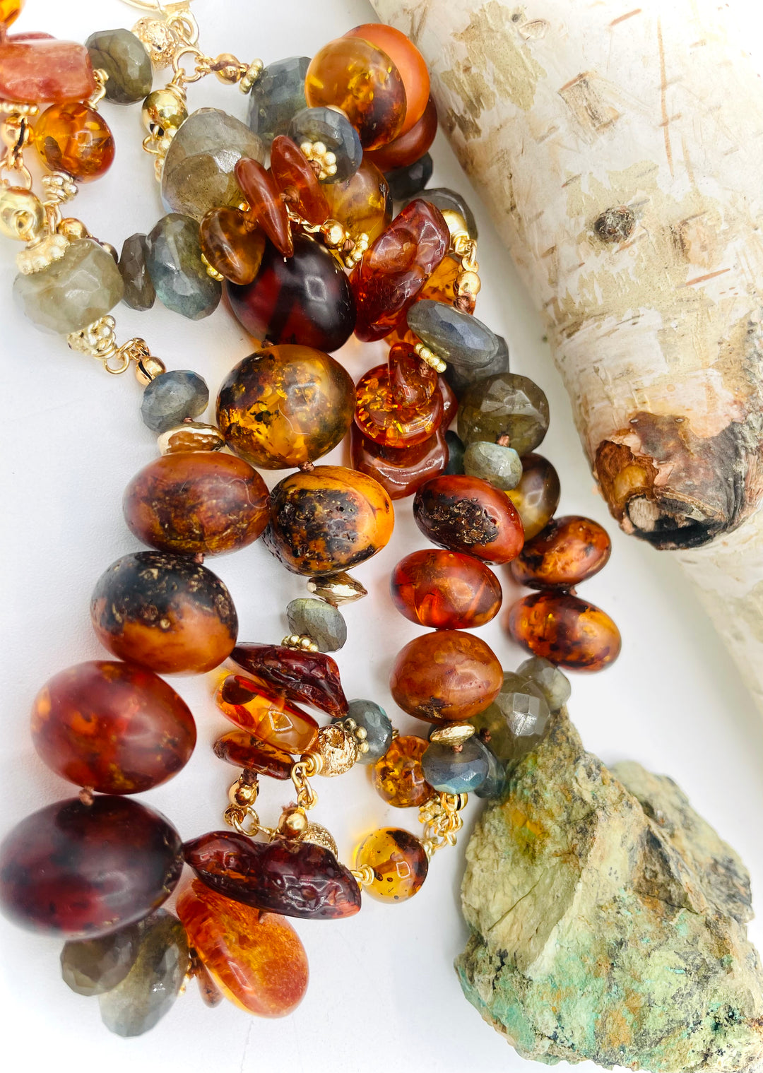 Silk knotted and wire wrapped treasure necklace featuring Baltic amber, labradorite, lava beads, and 14k gold accents. Available only from Rockstar Cowgirl online or in store in Cody, Wyoming. 