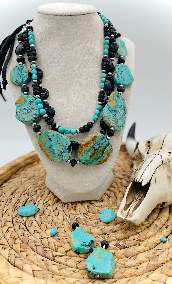 Beaded three strand necklace featuring Kingman turquoise, onyx, spinel, sterling silver, and finished with deer lace and slide bead. Includes matching earrings. Available only from Rockstar Cowgirl online or in store in Cody, Wyoming.