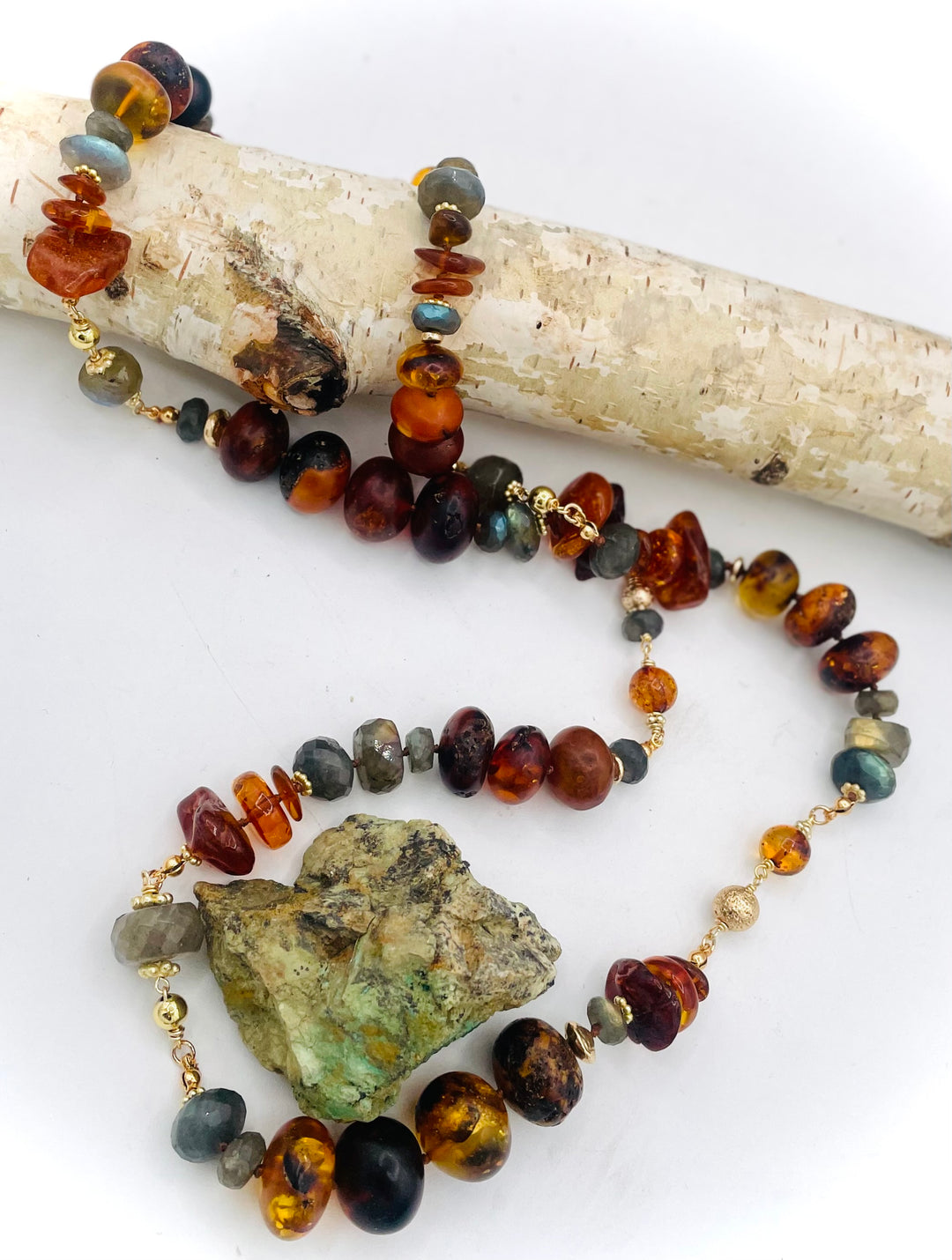 Silk knotted and wire wrapped treasure necklace featuring Baltic amber, labradorite, lava beads, and 14k gold accents. Available only from Rockstar Cowgirl online or in store in Cody, Wyoming. 