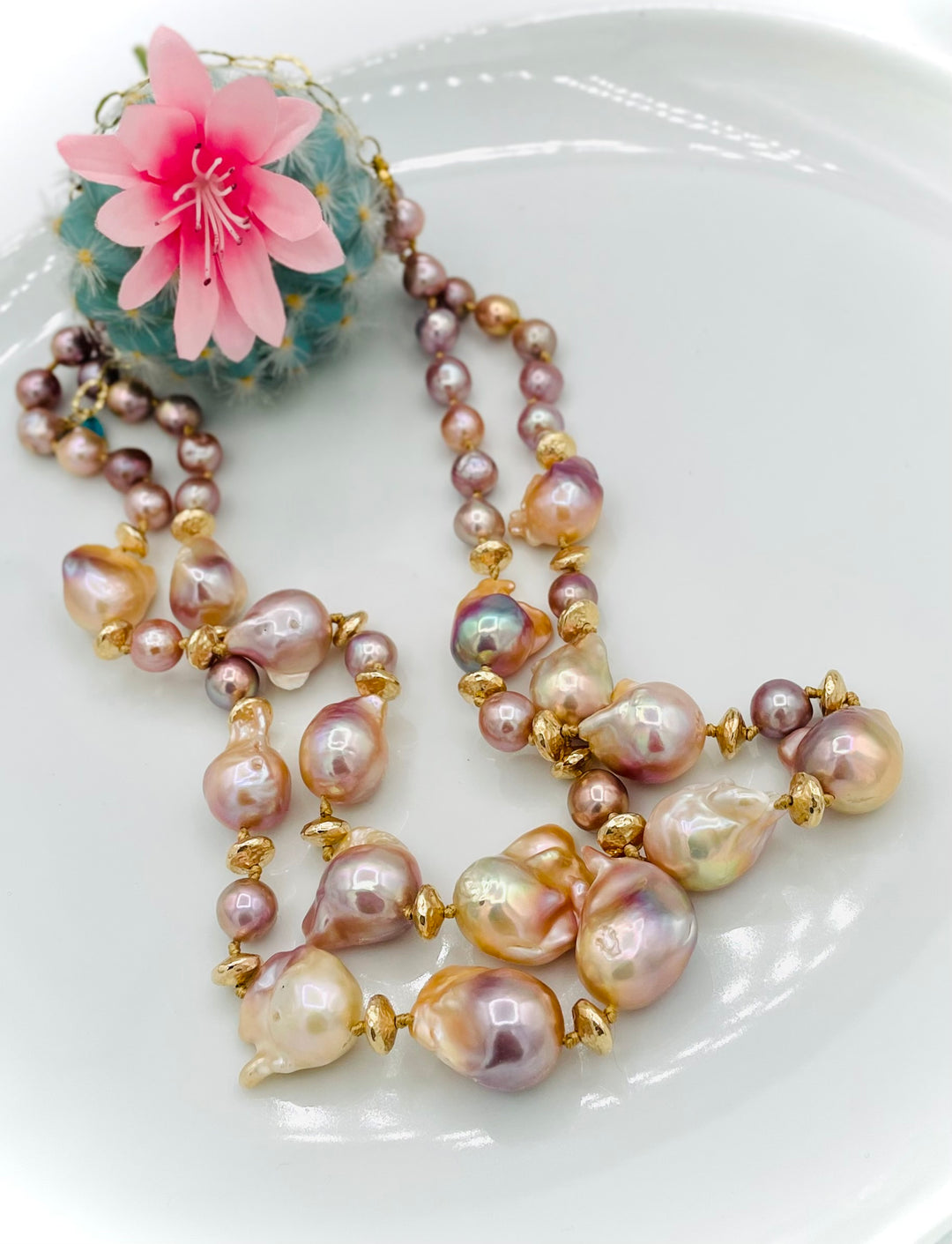 Silk knotted 2 strand necklace featuring flame ball natural luster pearls, smaller pink pearls, 14k gold accents, and finished a small turquoise heart at the back. Available only from Rockstar Cowgirl online or in store in Cody, Wyoming.