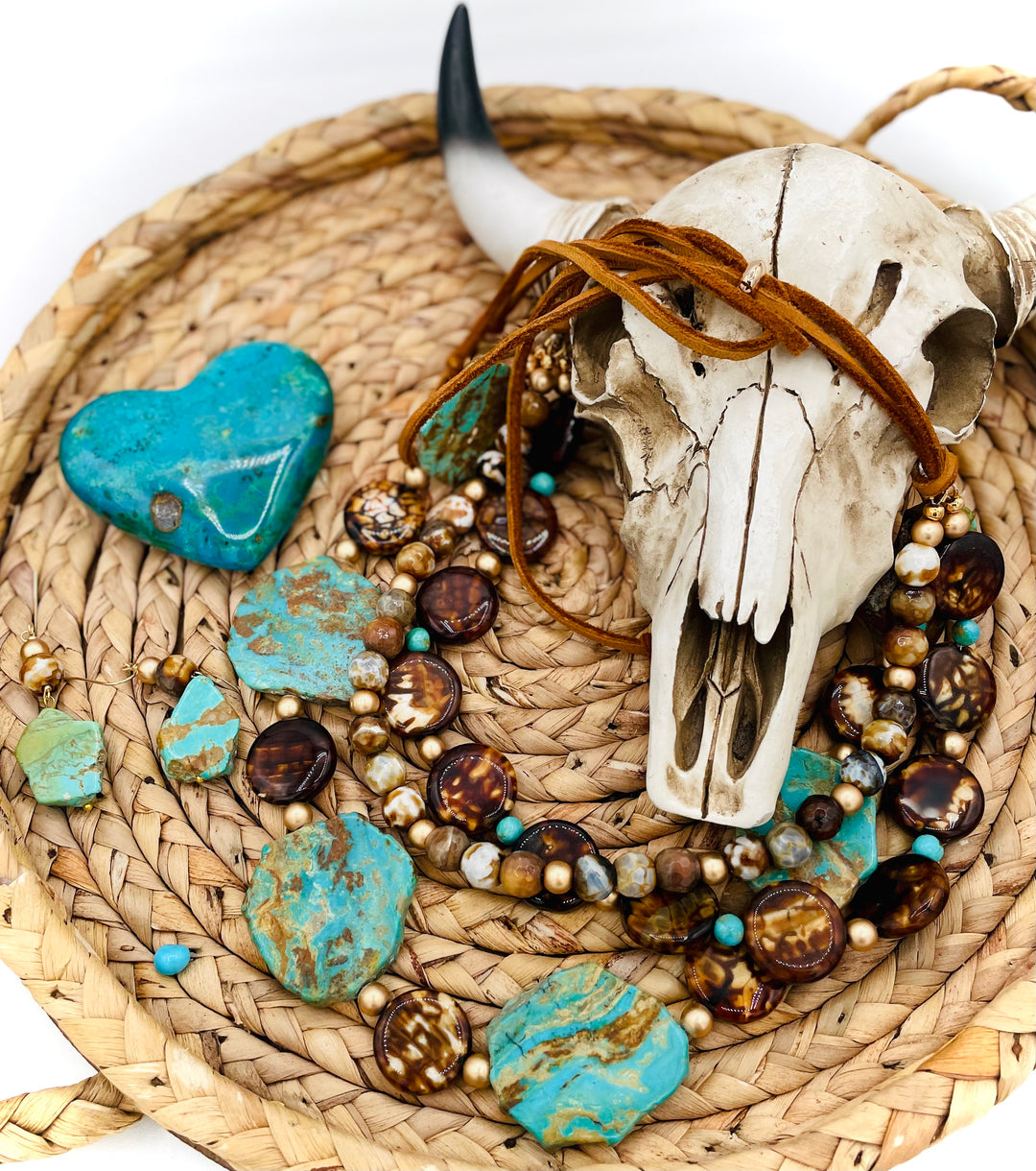 Beaded three strand necklace featuring Kingman turquoise, fire agate, gold hematite, deer lace, and slide bead. Includes matching earrings. Available only from Rockstar Cowgirl online or in store in Cody, Wyoming.