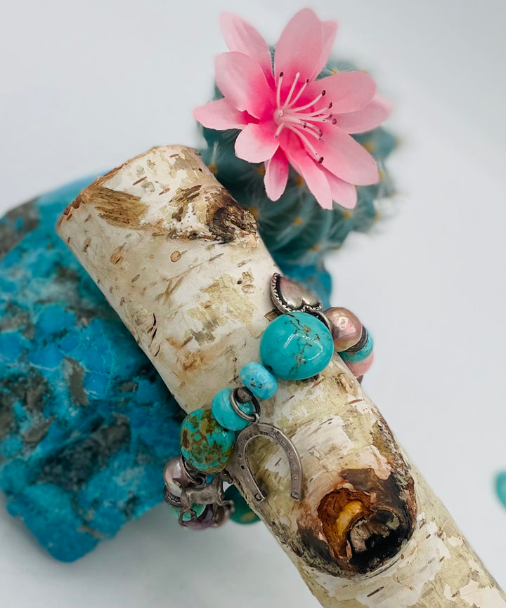 Beaded stretch bracelet featuring Kingman turquoise, royal beauty turquoise, pearls, rhodochrosite, purple turquoise, sterling silver beads and vintage sterling silver charms. Available only from Rockstar Cowgirl online or in store in Cody, Wyoming.