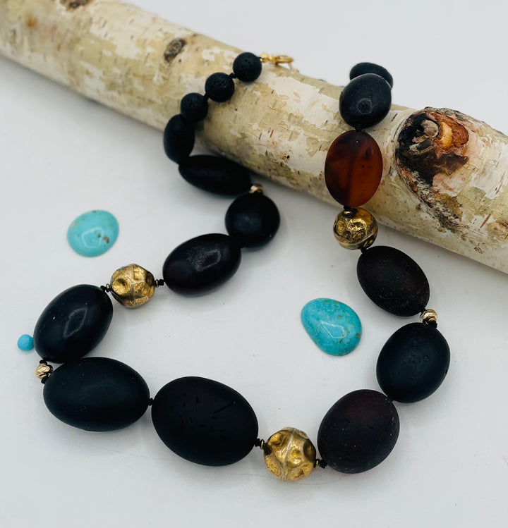 Silk knotted necklace featuring black Baltic amber nuggets, lava, and 14K gold beads. Available only from Rockstar Cowgirl online or in store in Cody, Wyoming.