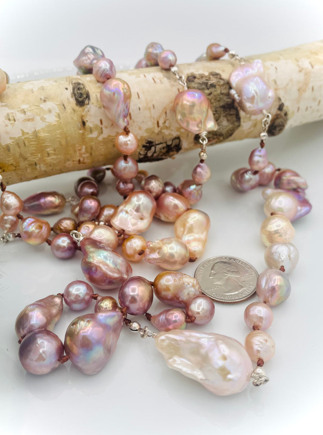 Silk knotted and wire wrapped long treasure necklace featuring natural luster, baroque, Flameball, and Edison pearls with sterling silver accents. U.S. quarter for size reference. Available only from Rockstar Cowgirl online or in store in Cody, Wyoming.