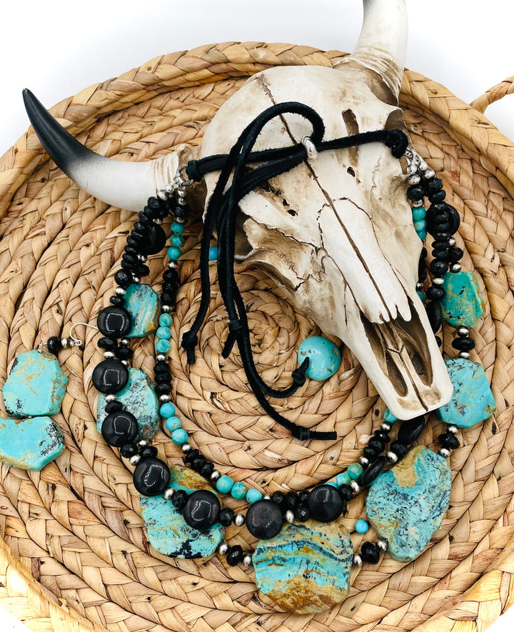 Beaded three strand necklace featuring Kingman turquoise, onyx, spinel, sterling silver, and finished with deer lace and slide bead. Includes matching earrings. Available only from Rockstar Cowgirl online or in store in Cody, Wyoming.