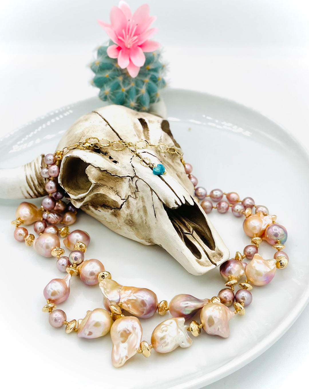 Silk knotted 2 strand necklace featuring flame ball natural luster pearls, smaller pink pearls, 14k gold accents, and finished a small turquoise heart at the back. Available only from Rockstar Cowgirl online or in store in Cody, Wyoming.