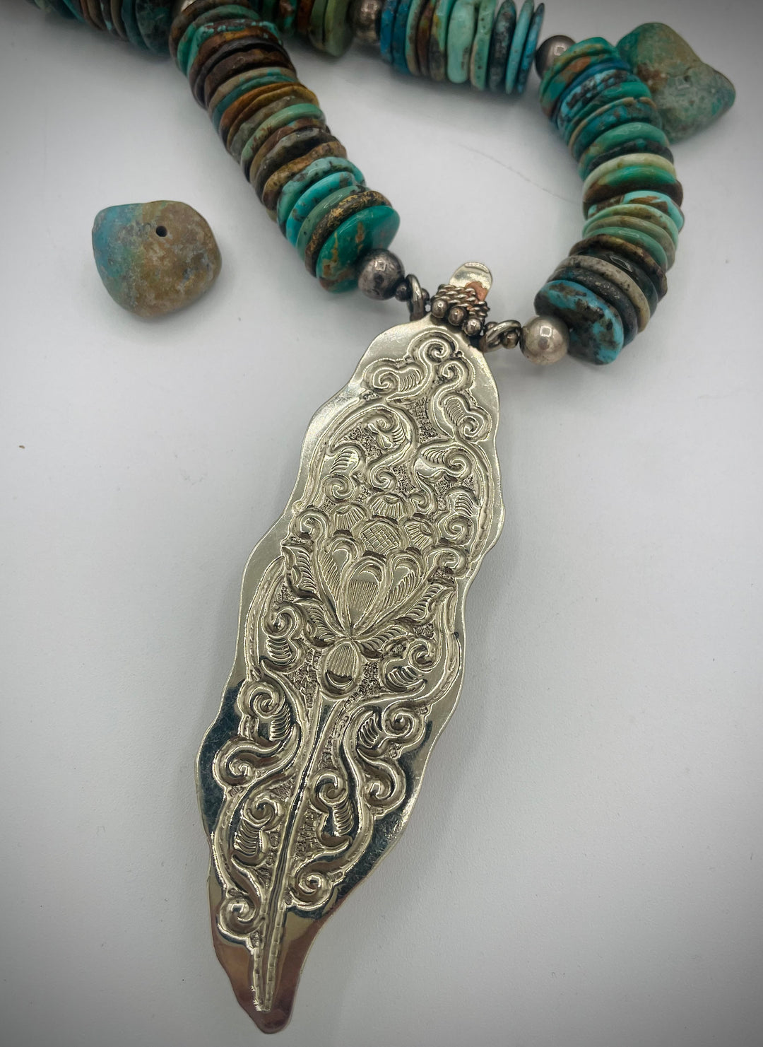 Handmade beaded necklace featuring turquoise discs, sterling silver beads, and Tibetan silver pendent with turquoise inlays. Available only from Rockstar Cowgirl online or in store in Cody, Wyoming.