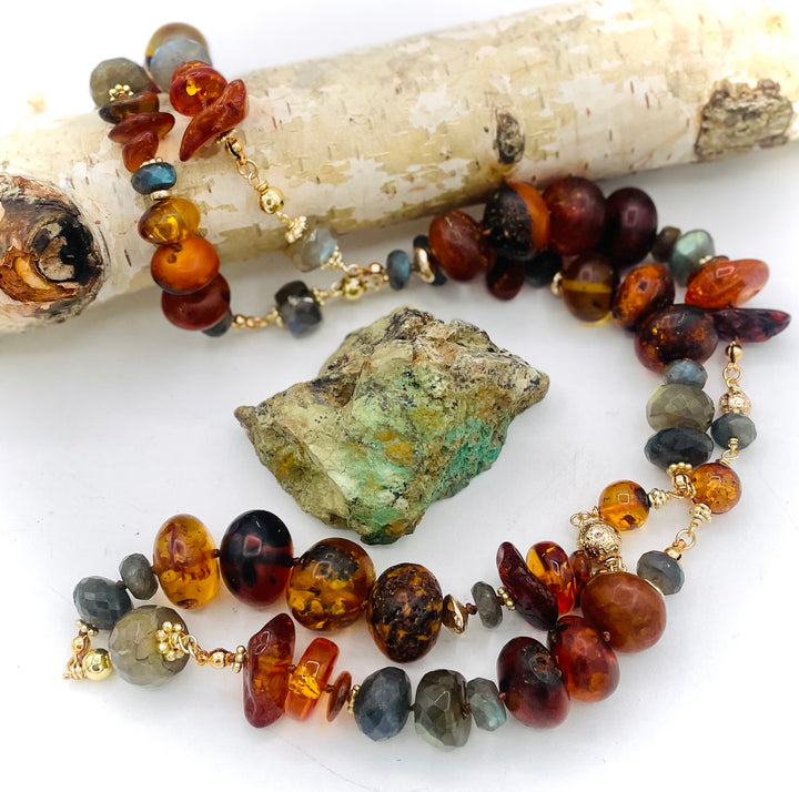 Silk knotted and wire wrapped treasure necklace featuring Baltic amber, labradorite, lava beads, and 14k gold accents. Available only from Rockstar Cowgirl online or in store in Cody, Wyoming. 