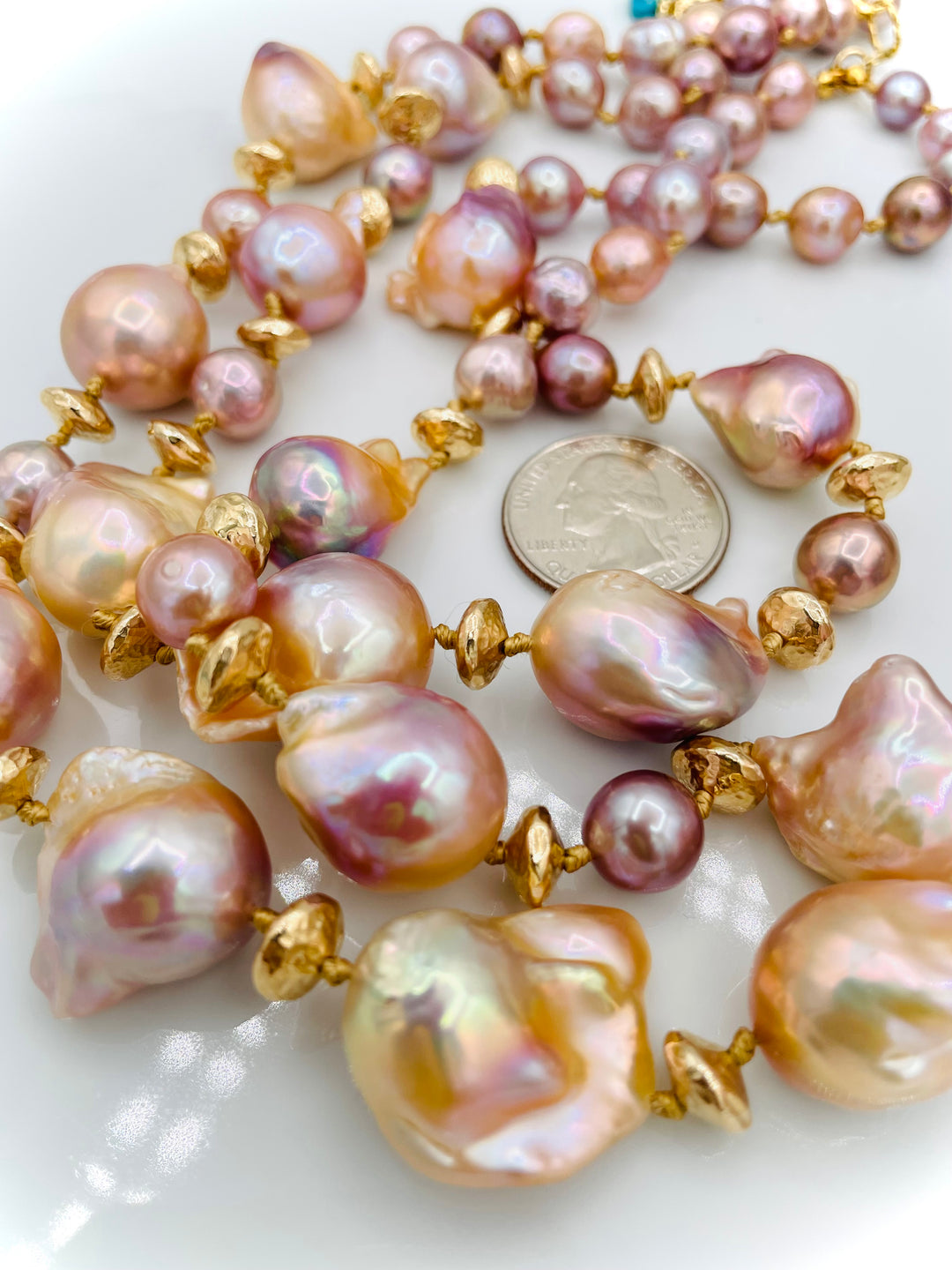 Silk knotted 2 strand necklace featuring flame ball natural luster pearls, smaller pink pearls, 14k gold accents, and finished a small turquoise heart at the back. U.S. quarter for size reference. Available only from Rockstar Cowgirl online or in store in Cody, Wyoming.