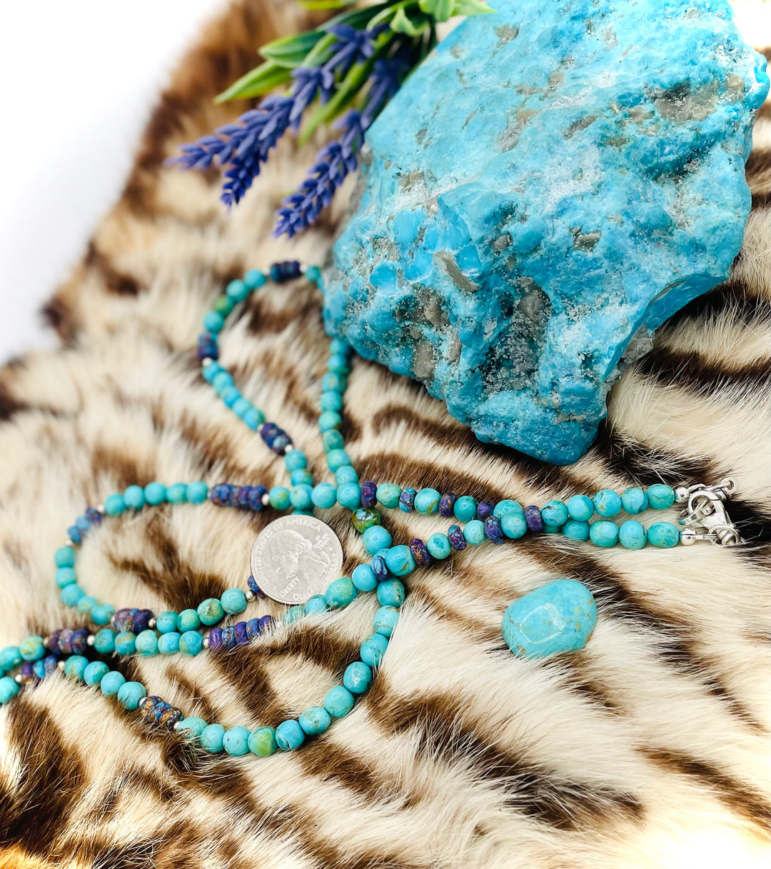 Beaded invention necklace featuring Kingman turquoise, purple Mojave turquoise, sterling silver beads, sterling silver swivel lobsters, eye glasses loops, cell phone case attachment bracket. U.S. quarter for size reference. Available only from Rockstar Cowgirl online or in store in Cody, Wyoming.