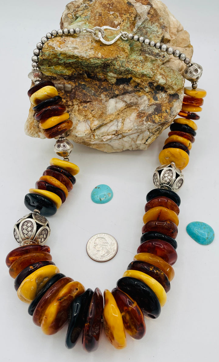 Beaded necklace featuring multi colored Baltic amber discs an handmade sterling silver beads. U.S. quarter for size reference. Available only from Rockstar Cowgirl online or in store in Cody, Wyoming.