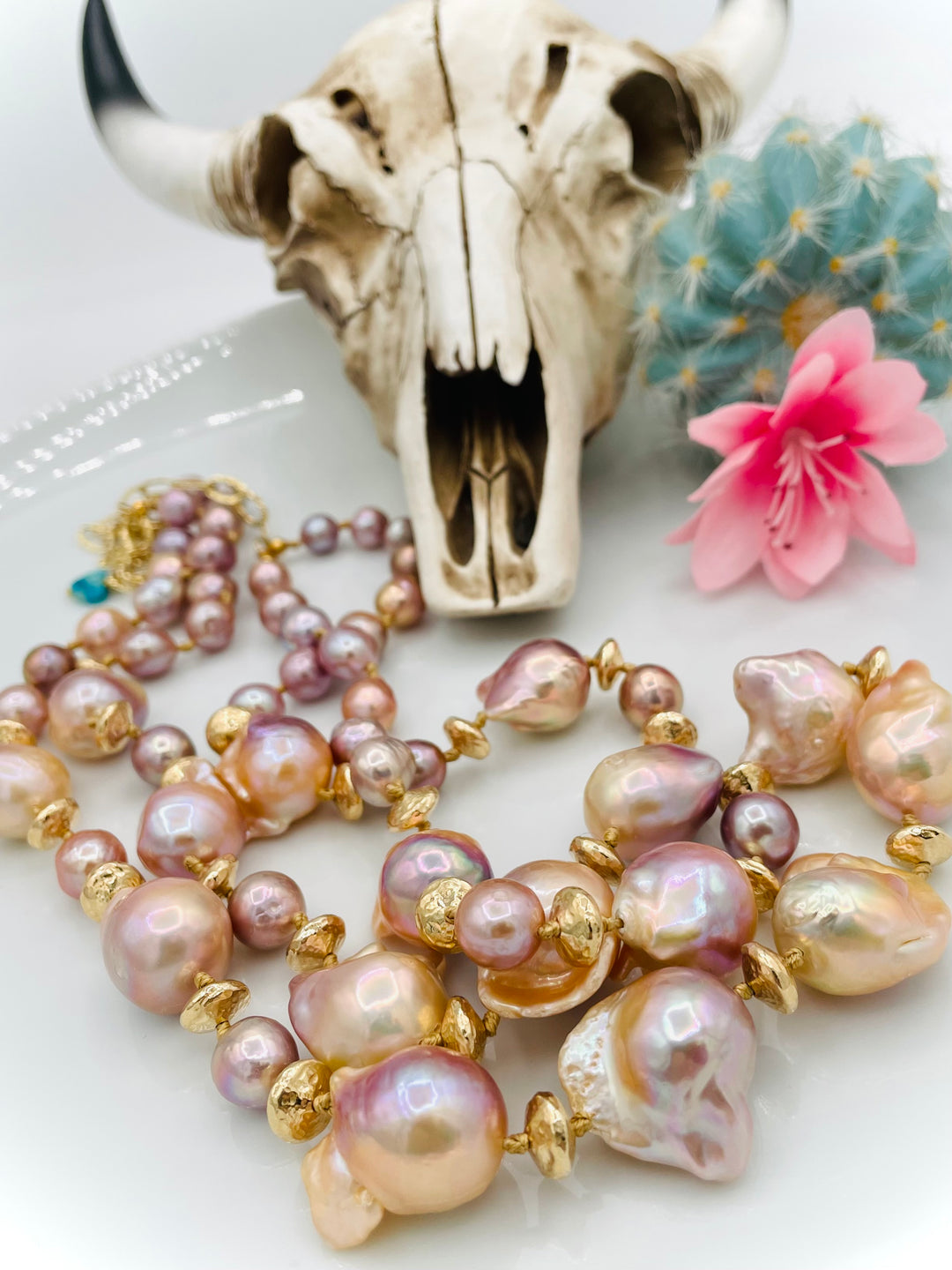 Silk knotted 2 strand necklace featuring flame ball natural luster pearls, smaller pink pearls, 14k gold accents, and finished a small turquoise heart at the back. Available only from Rockstar Cowgirl online or in store in Cody, Wyoming.